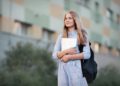 First day back to school. School girl portrait of teen model with backpack, textbooks notebooks